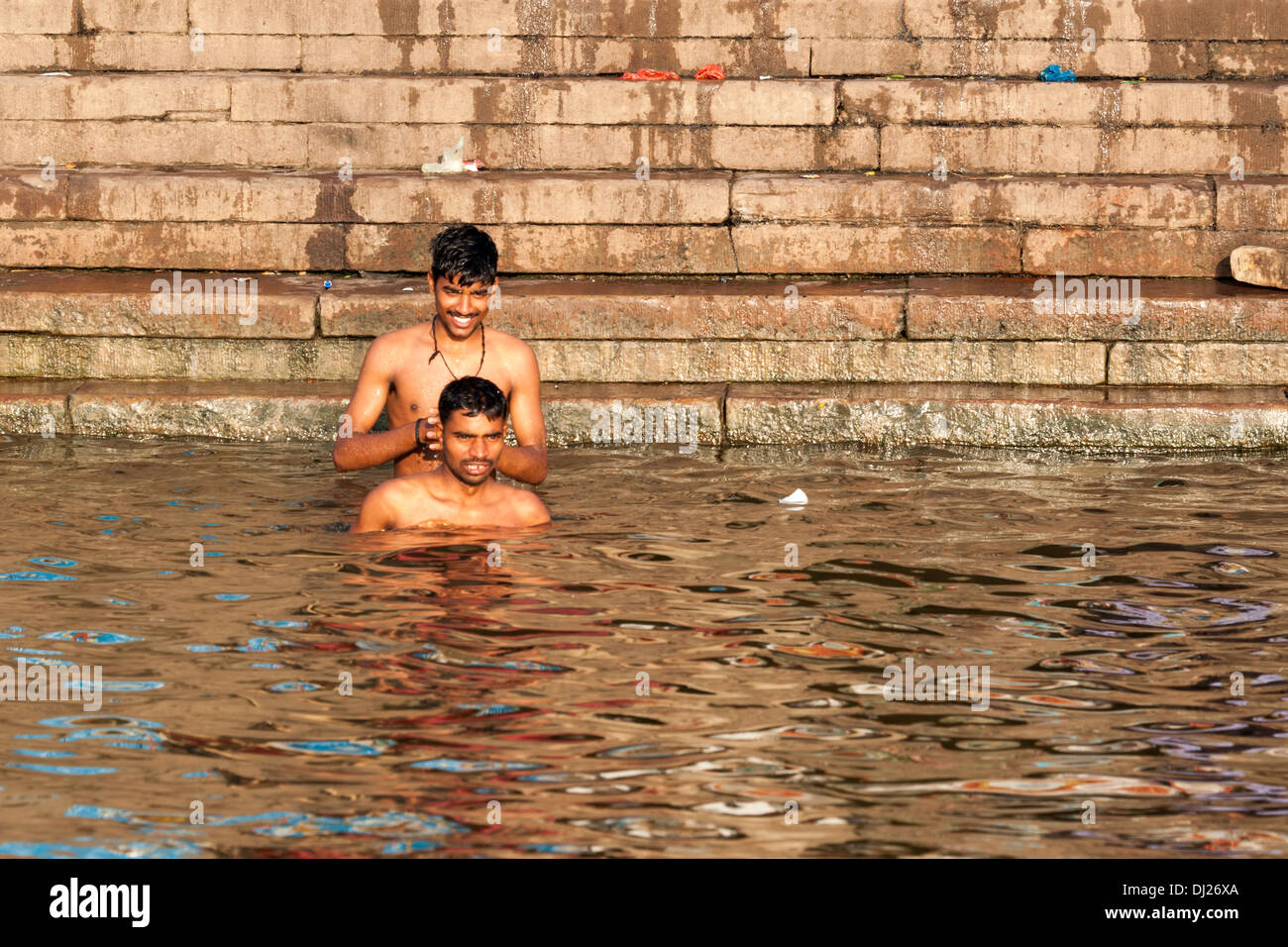 VARANASI, INDIA - Febbraio 2012: due uomini indù prende santo tuffo nel fiume Gange a Varanasi, in India nel febbraio 2012. Foto Stock