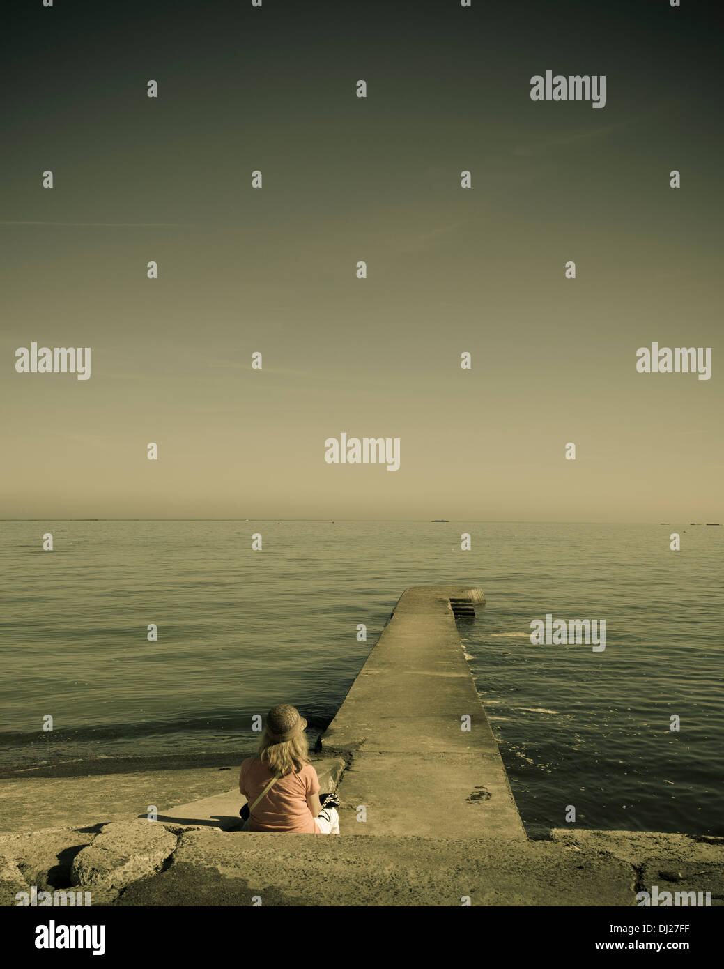 Una persona che guarda al mare a qualcosa di invisibile. Foto Stock