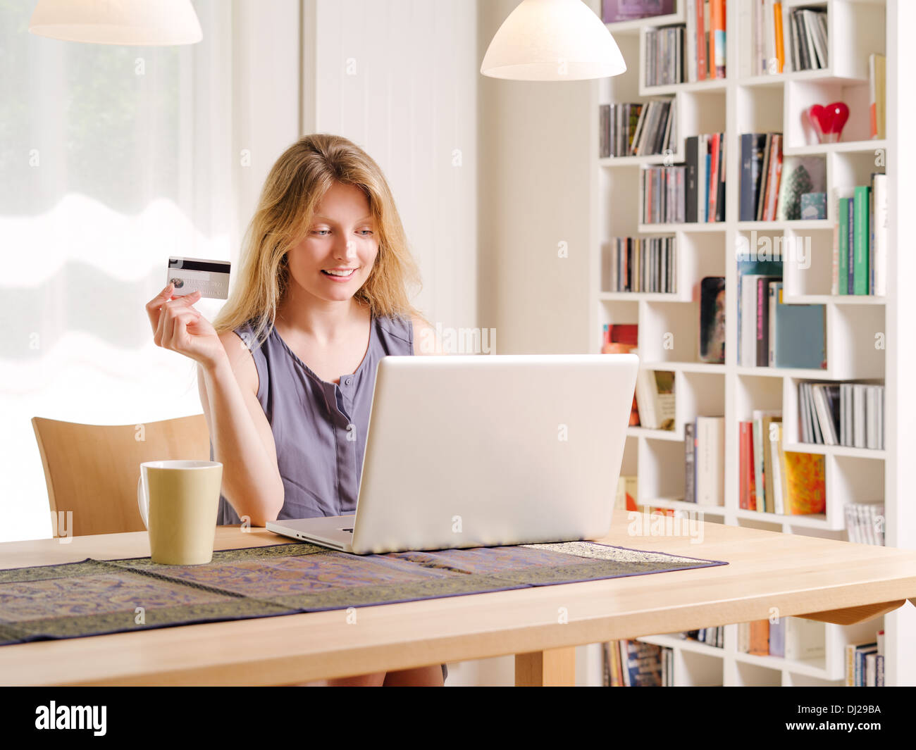 Foto di una giovane e bella donna shopping online e pagare con una carta di credito. Le informazioni della carta di credito è fittizia. Foto Stock