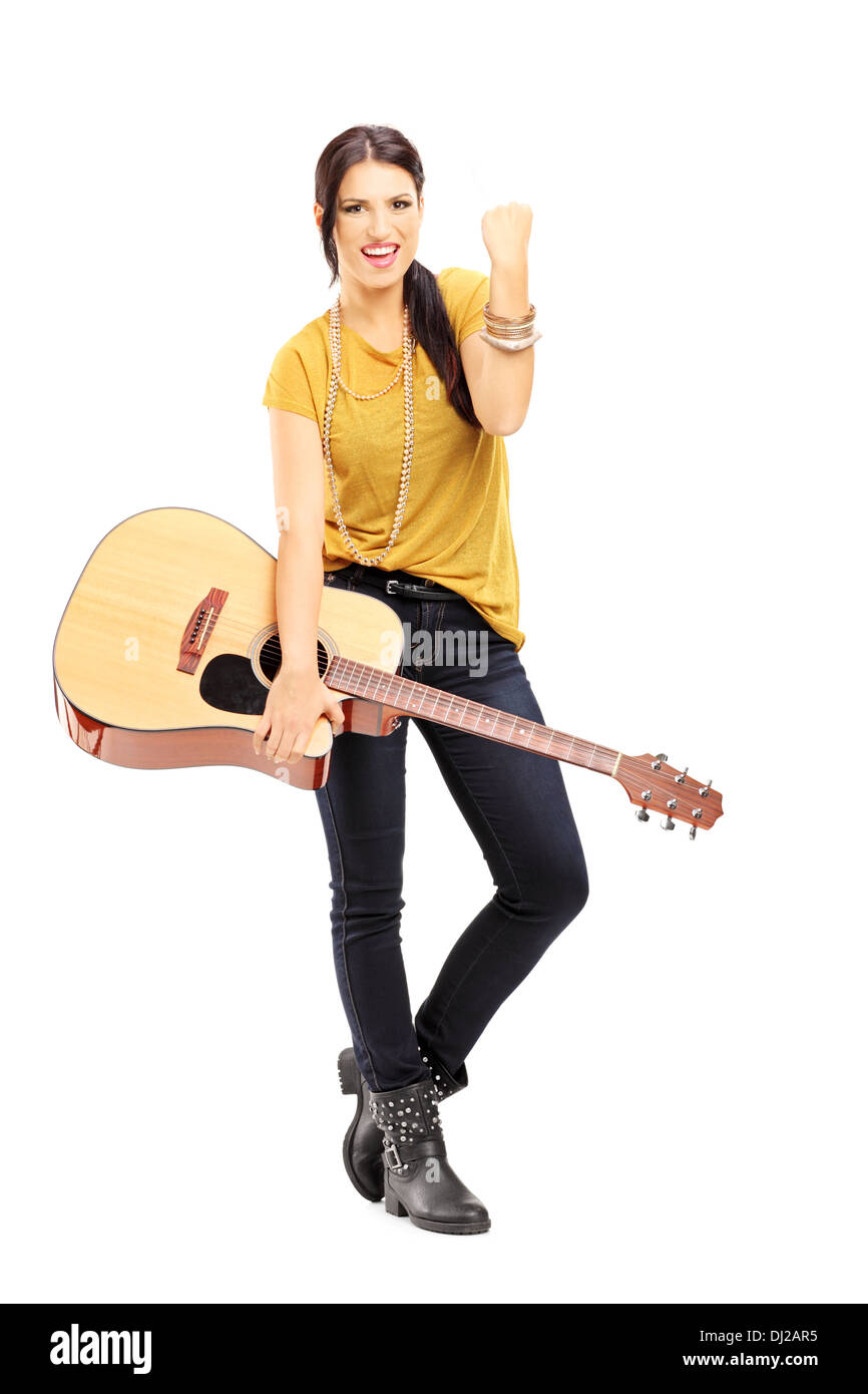 A piena lunghezza Ritratto di una giovane donna in possesso di una chitarra acustica e gesticolando felicità Foto Stock