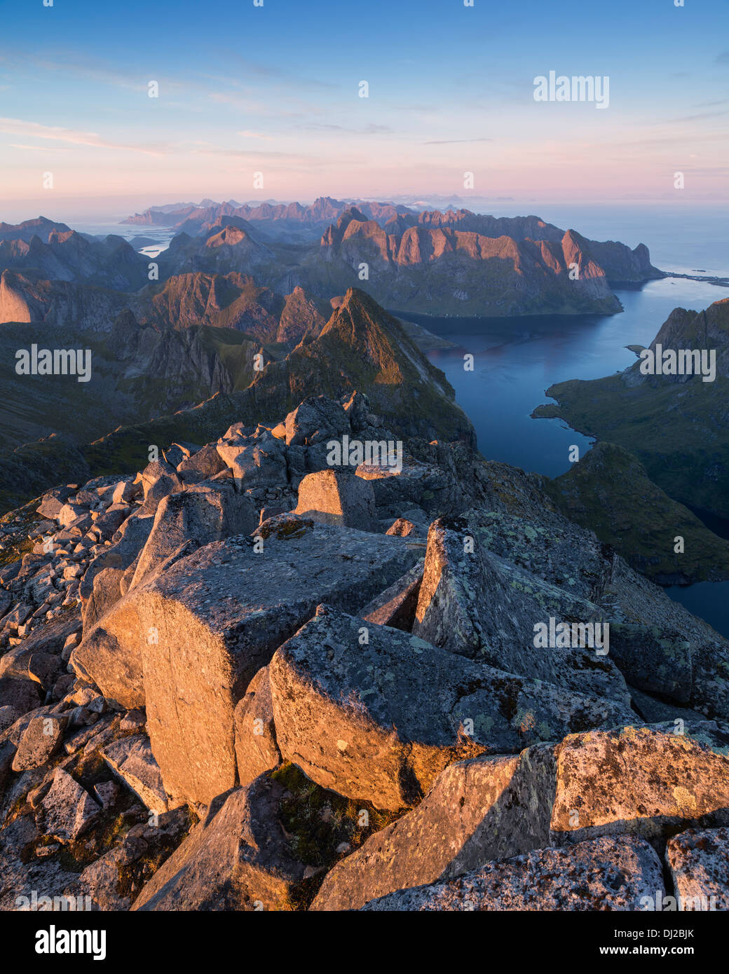 Luce della Sera oltre il paesaggio di montagna dalla vetta rocciosa di Hermannsdalstinden, Moskenesoy, Isole Lofoten in Norvegia Foto Stock