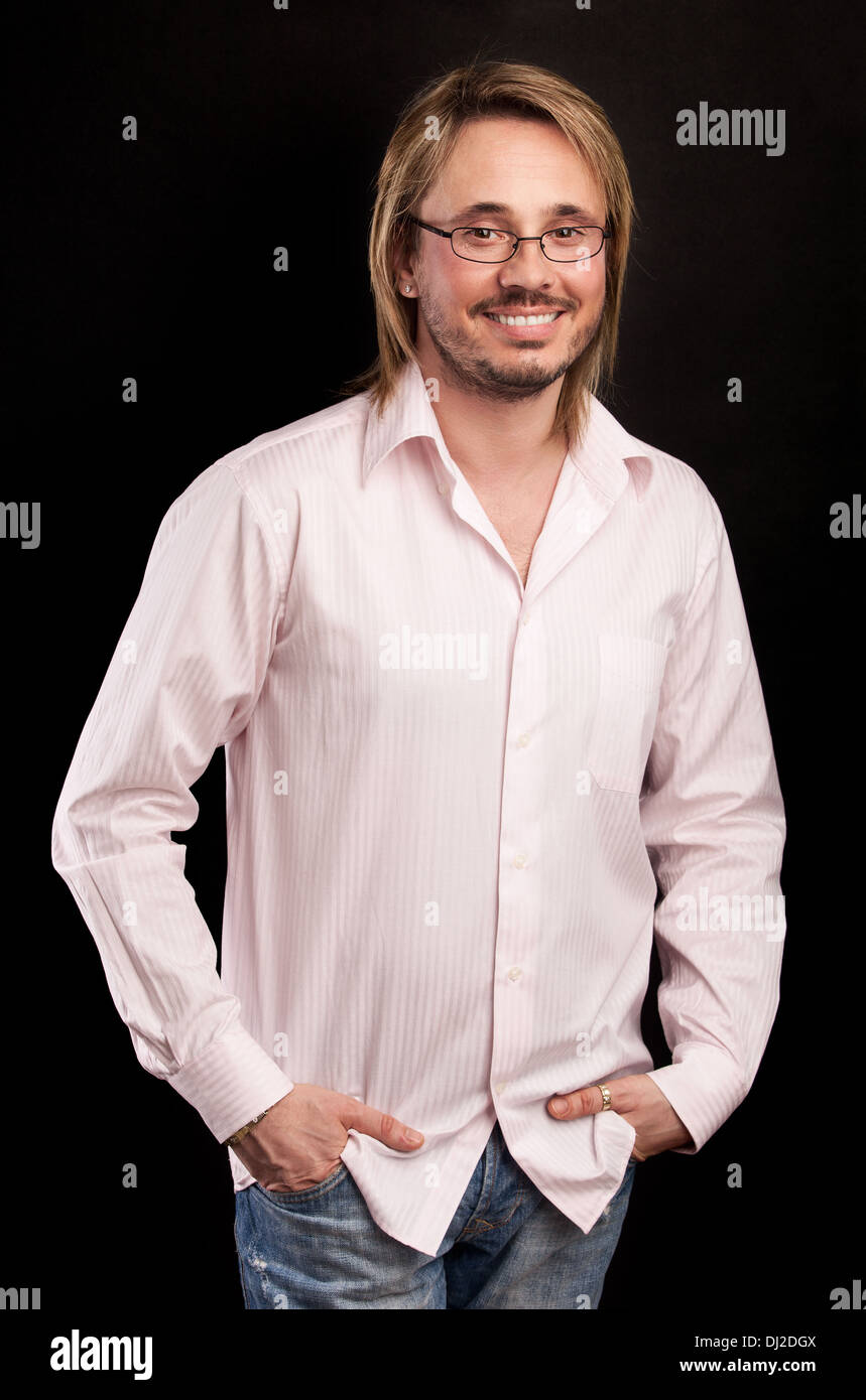 Ritratto di bel giovane uomo sorridente su sfondo nero Foto Stock