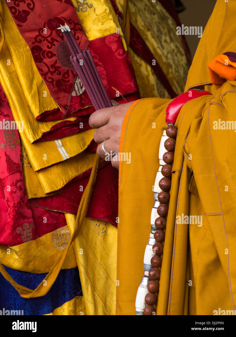 Il Bhutan, Thimpu Dzong, Tsechu annuale, le mani del monaco holding di fumare bastoncini di incenso Foto Stock