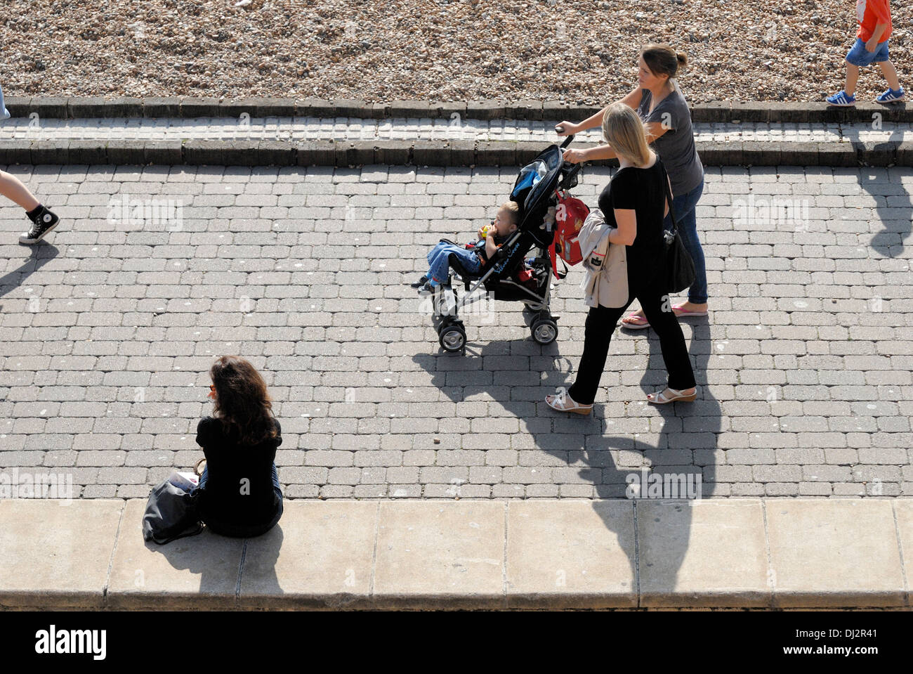 Brighton, East Sussex, Inghilterra, Regno Unito. Donne a spingere passeggino lungo il lungomare Foto Stock