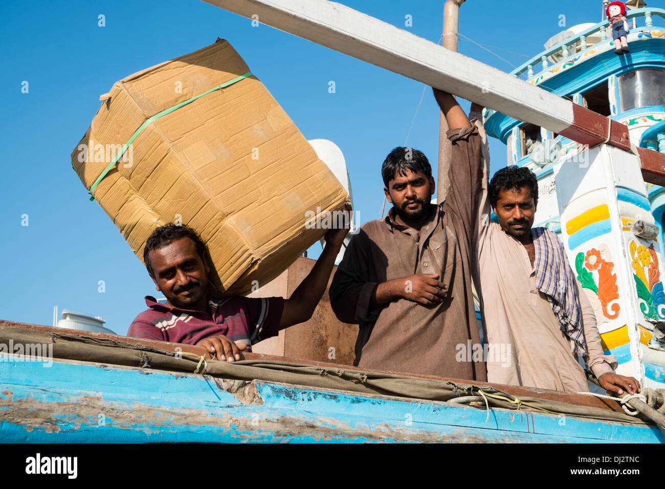 Gli uomini carichi di caricamento sul Dhow alla banchina di carico sul Creek di Dubai Emirati Arabi Uniti Foto Stock