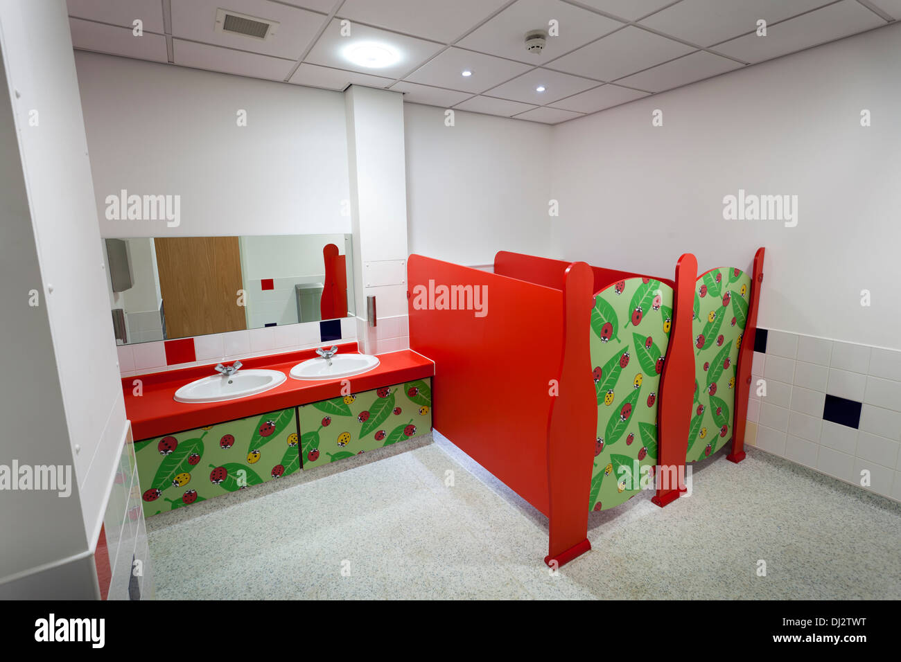 Neonati colorati bagni con pareti basse cubicoli e lavabi. Foto Stock