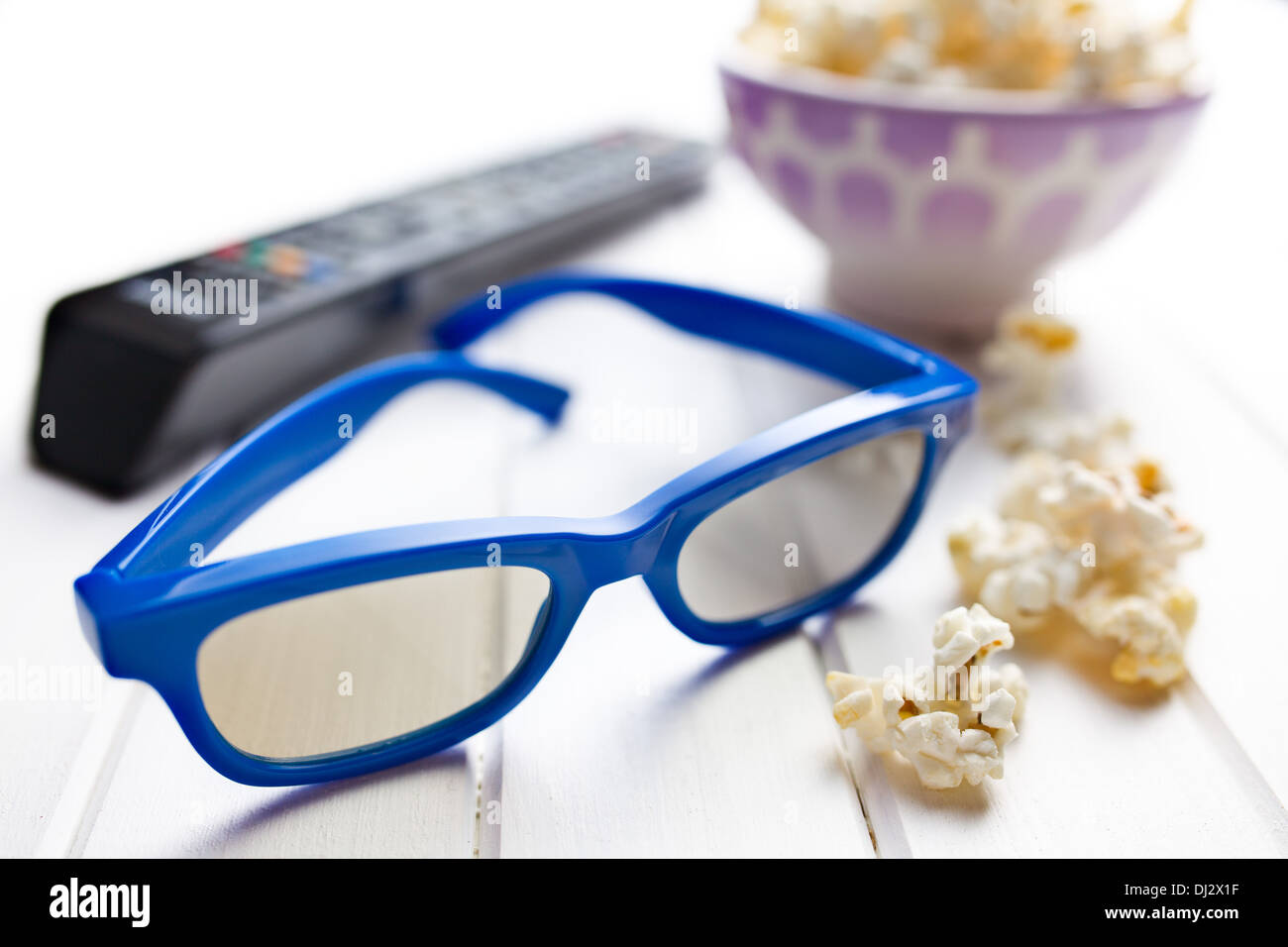 Occhiali 3d con popcorn su bianco tavolo in legno Foto Stock