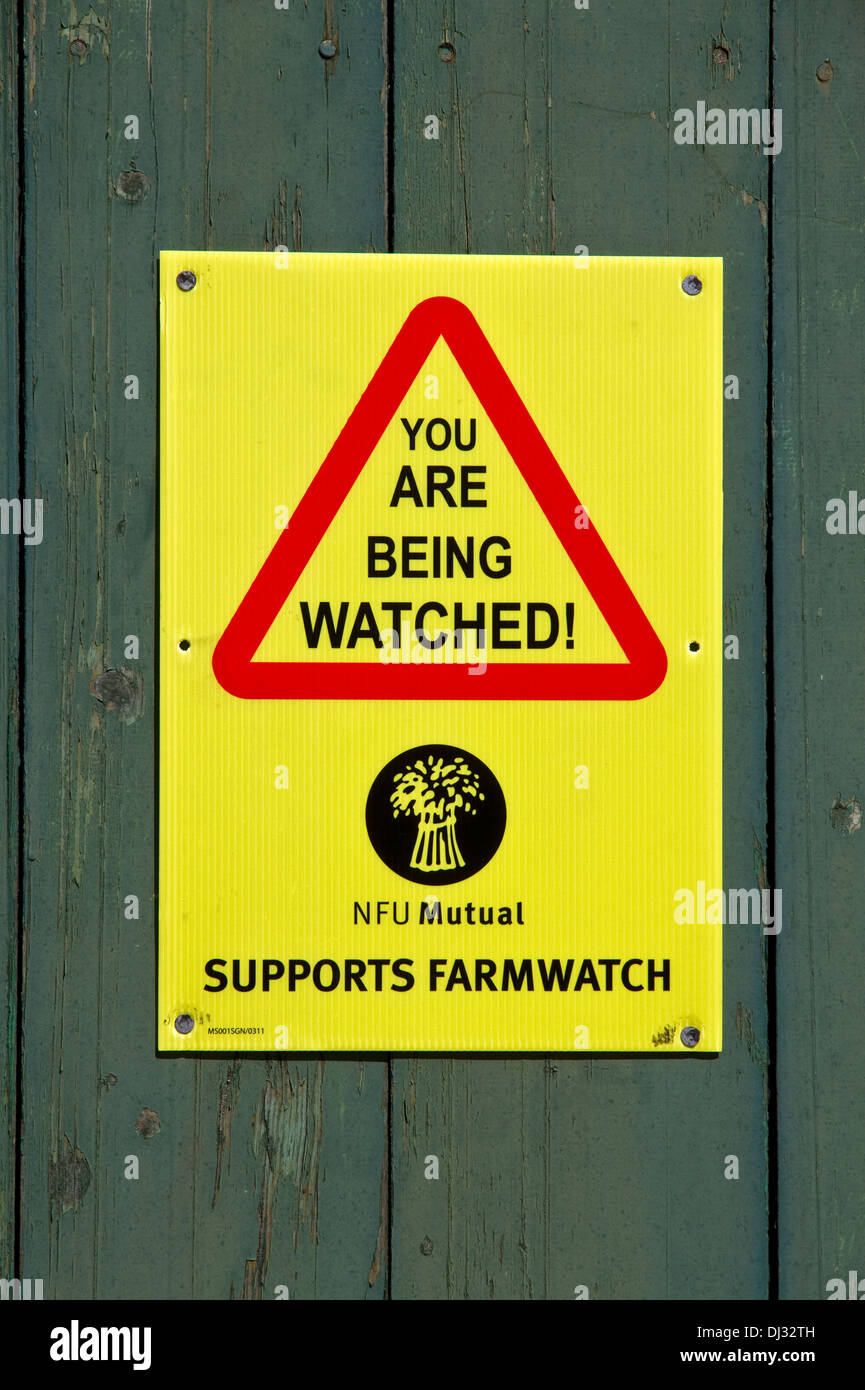 "Farmwatch' avviso ( per scoraggiare i furti) su porte in legno di pietra rurale granaio, Stonyhurst, Ribble Valley, Lancashire, Inghilterra, Regno Unito Foto Stock