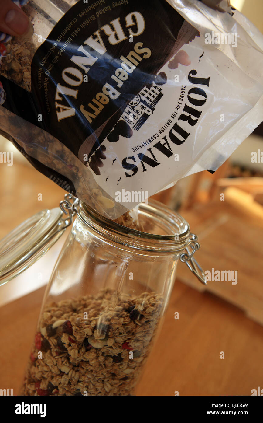 Jordan super berry granola essendo versata in un bicchiere vaso di storage Foto Stock