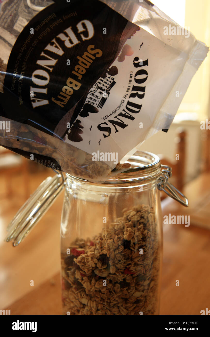 Jordan super berry granola essendo versata in un bicchiere vaso di storage Foto Stock