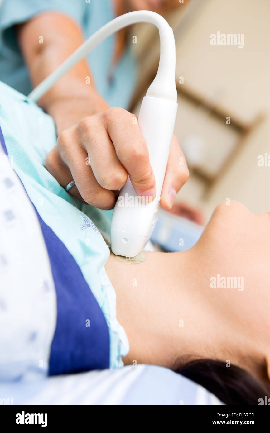 L'infermiera eseguendo ultrasuoni sul collo del paziente Foto Stock