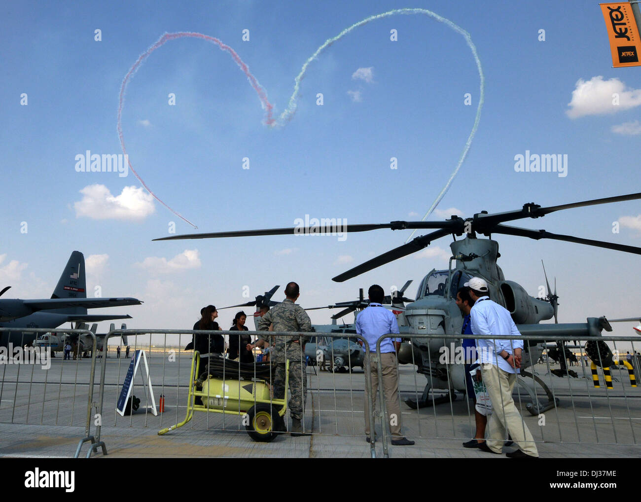 Gli spettatori guardano su come gli Emirati Arabi Uniti Air force team display, Al Fursan, disegna un cuore nel cielo sopra il 2013 Dubai Airshow di 17 presso il Dubai World Central aeroporto di Jebel Ali, nov. 18, 2013. L'evento biennale, che è uno dei più grandi aviat Foto Stock