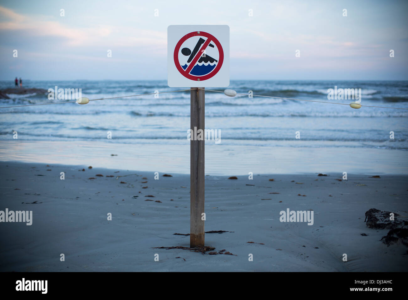 Un nessun segno di nuoto su una spiaggia al tramonto in Galveston, Texas, Stati Uniti d'America. Foto Stock