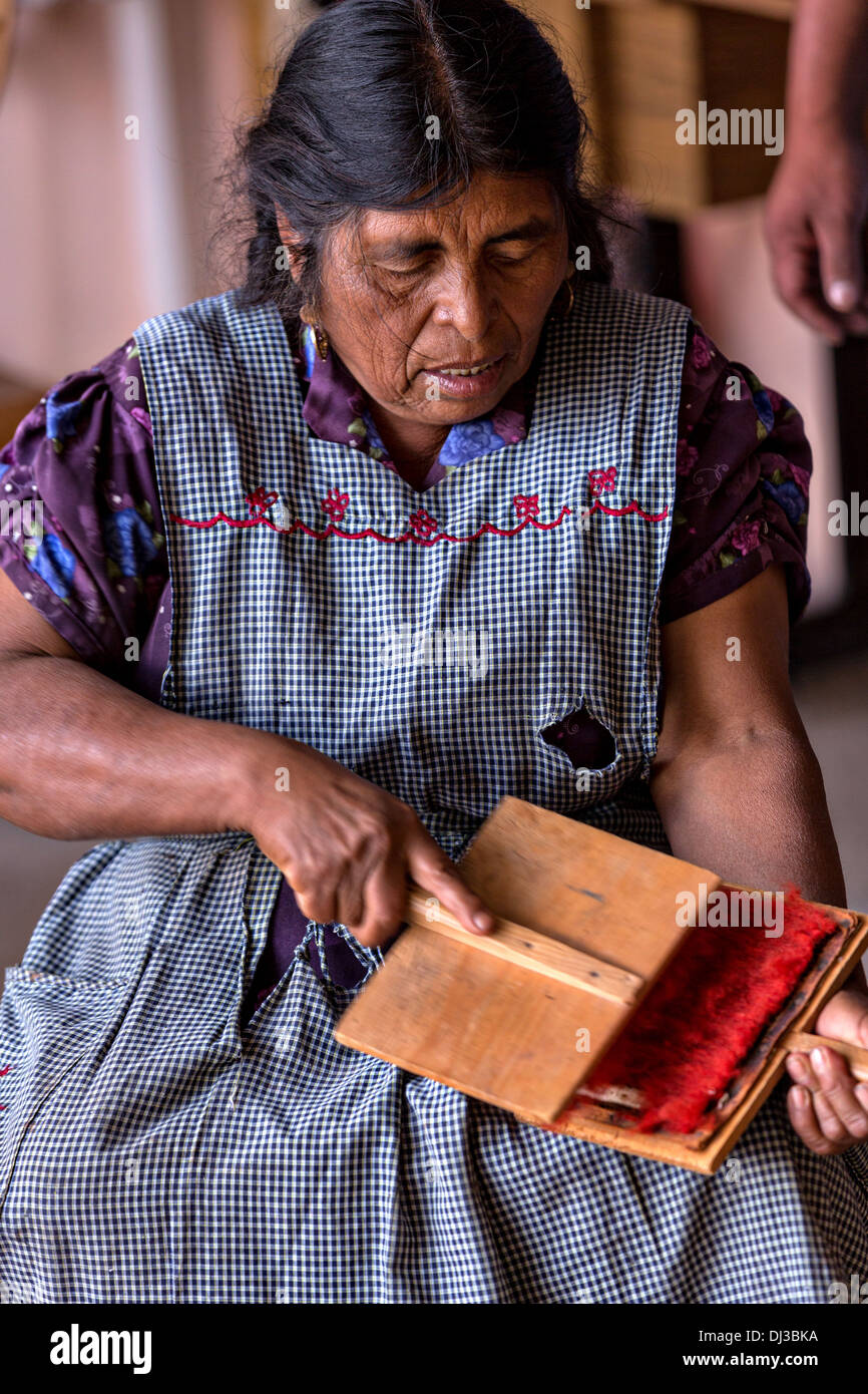 Un zapoteco donna indigena mano carte lana tinti in filo per essere utilizzati nella tessitura tappeti tradizionali in Teotitlan de Valle, Messico Foto Stock