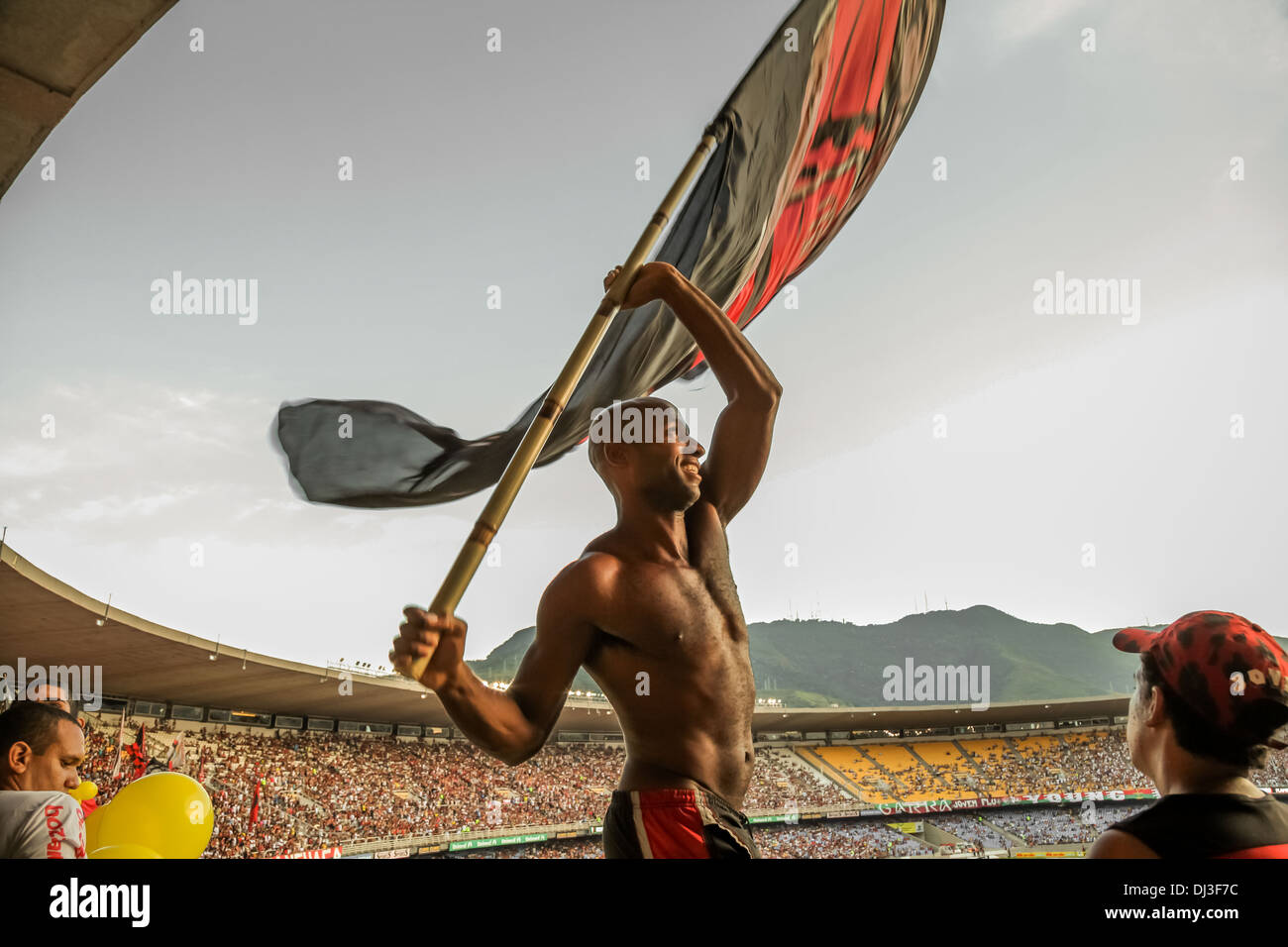 Un sostenitore sventola bandiera massiccia durante il Clube de Regatas do Flamengo (o Flamengo) partita di calcio al Maracanã Stadium. Foto Stock