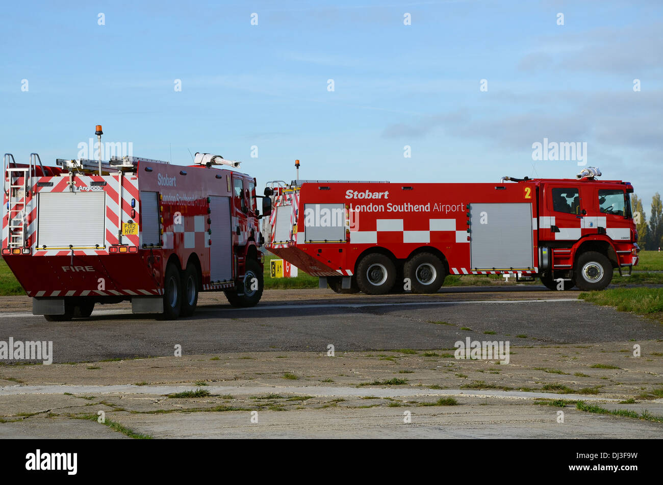 Aeroporto di due motori Fire unità fuori all'aeroporto di rullaggio che conduce alla pista su una esecuzione pratica. Londra aeroporto di Southend veicoli di emergenza Foto Stock