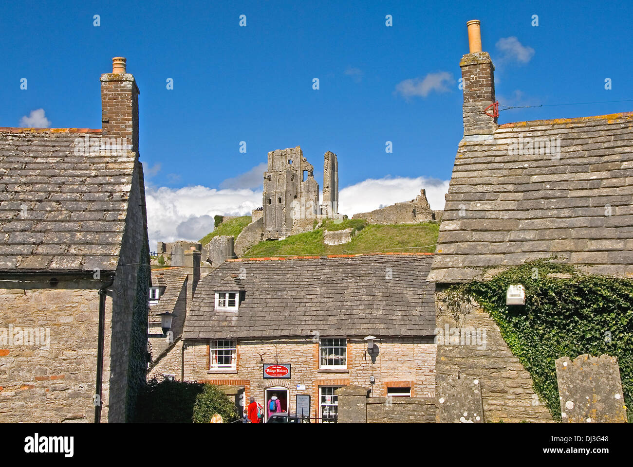 Le rovine di Corfe Castle stand alta al di sopra del piccolo villaggio con lo stesso nome in dorset, Inghilterra. Foto Stock