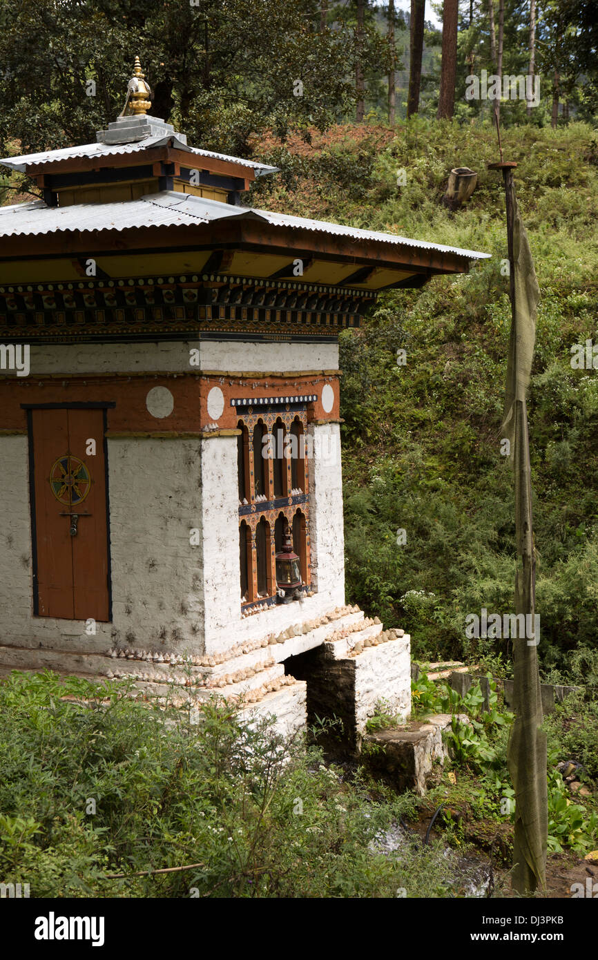 Il Bhutan, piccola strada acqua-guidato la preghiera ruota sulla strada per Dochu La pass Foto Stock