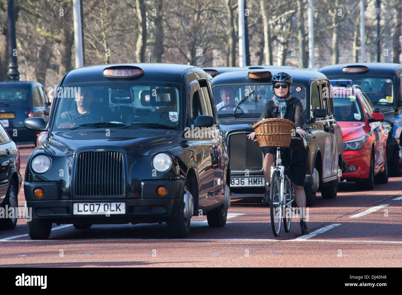 London black taxi in linea con il ciclista Foto Stock