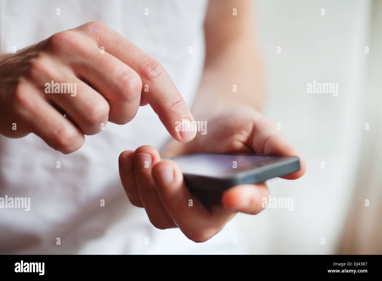 L'uomo mani toccano smartphone sfondo luminoso, primo piano Foto Stock