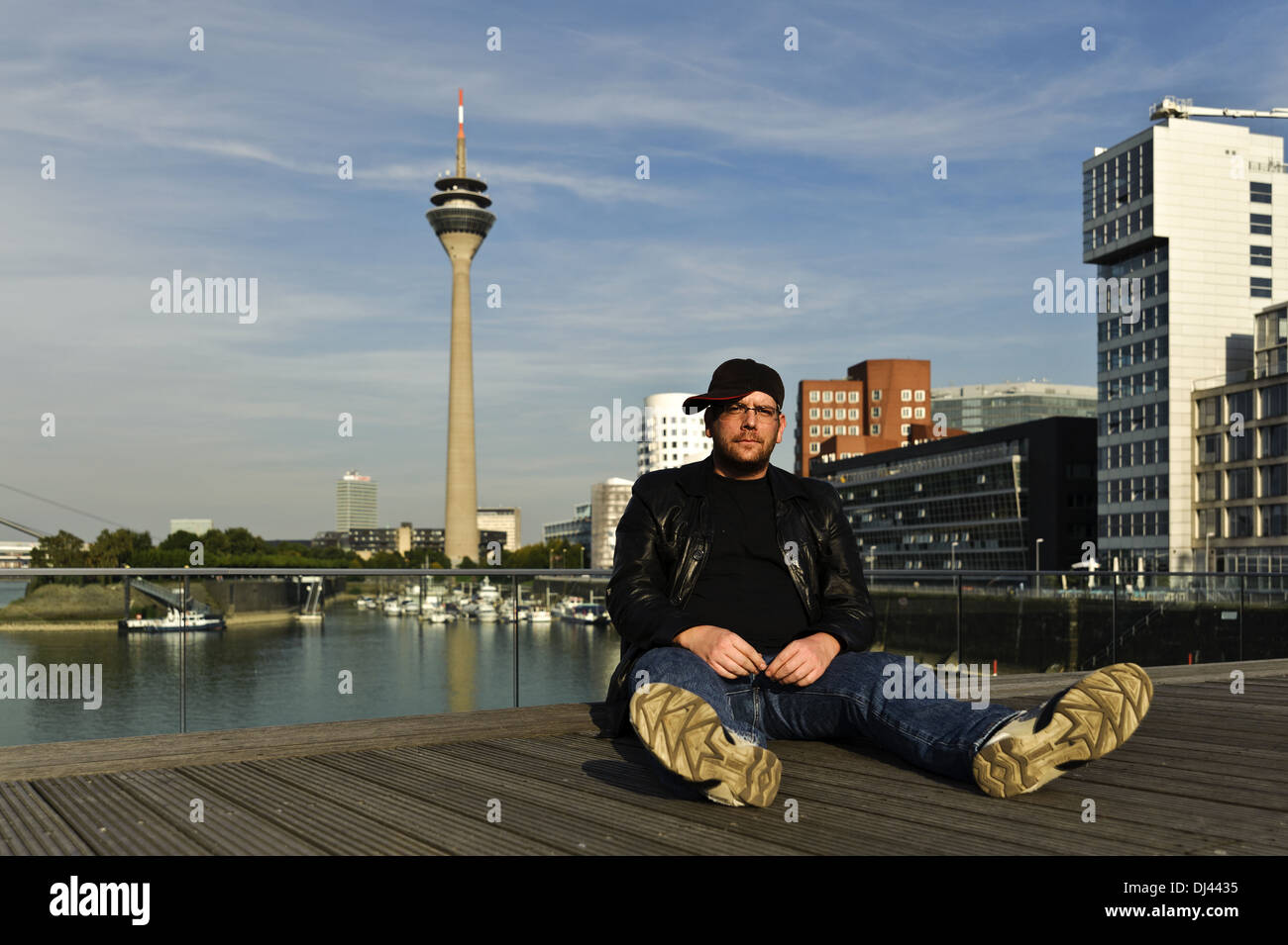 L uomo si siede a Düsseldorf Mediahafen Foto Stock