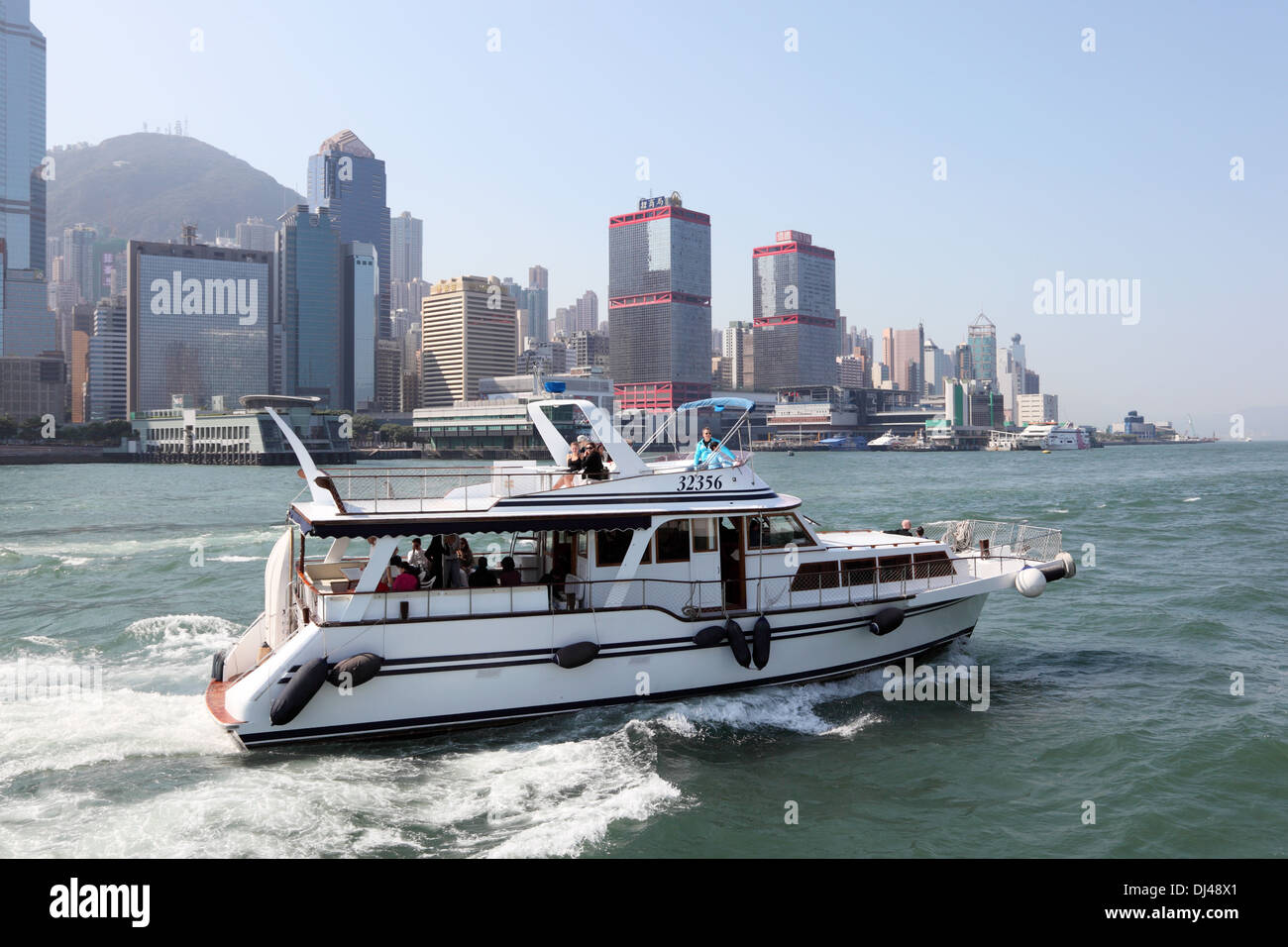 Yacht a motore con i turisti in crociera nel porto di Hong Kong Foto Stock