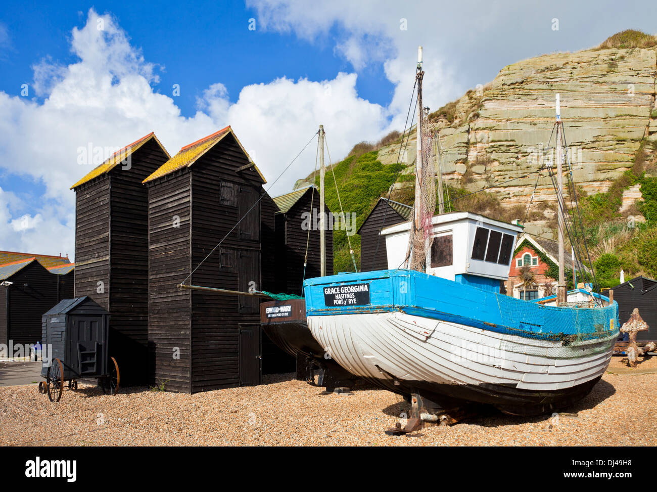 Neri alti tradizionale rete capannoni di asciugatura sulla spiaggia con barche da pesca a Hastings East Sussex England Regno Unito GB EU Europe Foto Stock