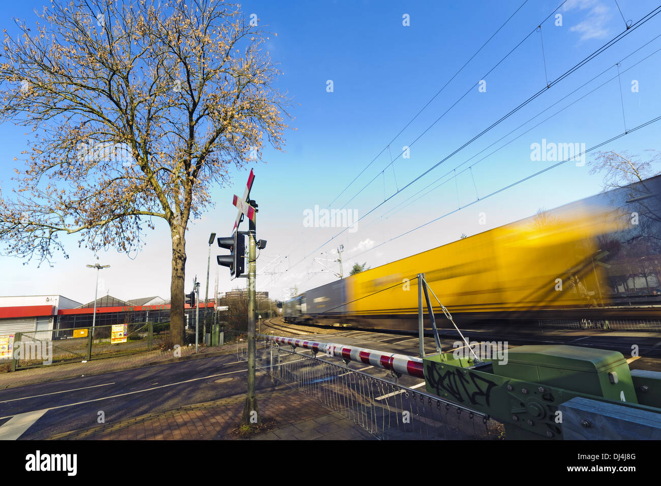 Un treno merci passando un passaggio a livello Foto Stock