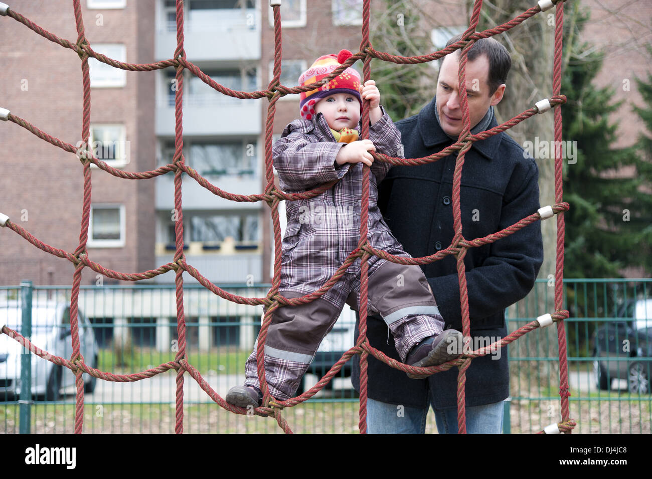 Bambina su una rete da arrampicata Foto Stock