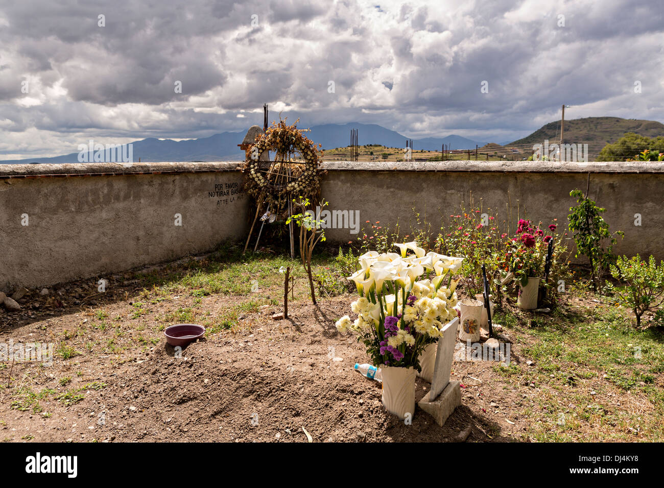 Fiori decorare tombe in un piccolo cimitero in memoria di un membro della famiglia durante il giorno dei morti festival noto in spagnolo come Día de Muertos Ottobre 30, 2013 in Teotitlan, Messico. Foto Stock