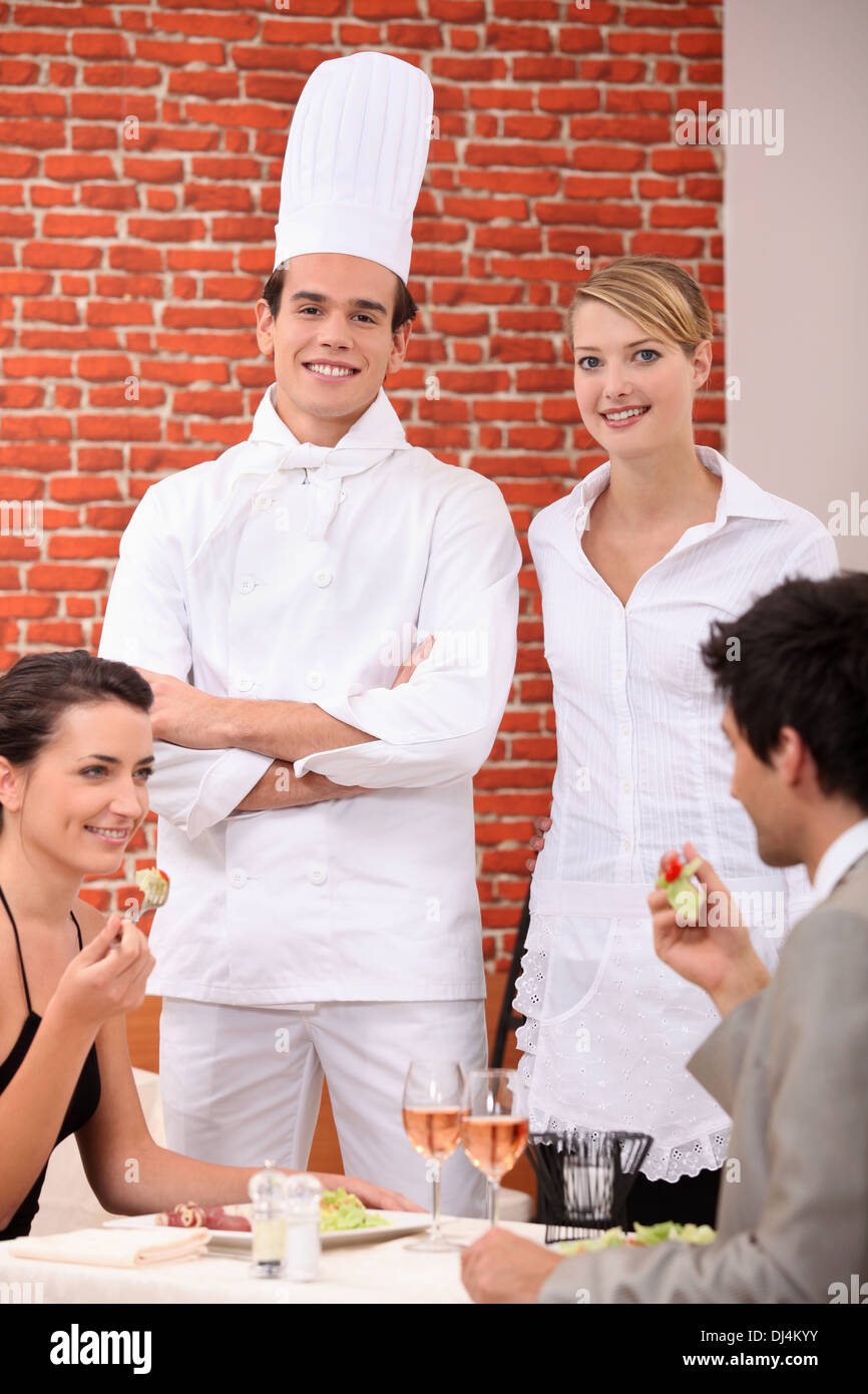 Un cuoco e una cameriera lavora in un ristorante Foto Stock