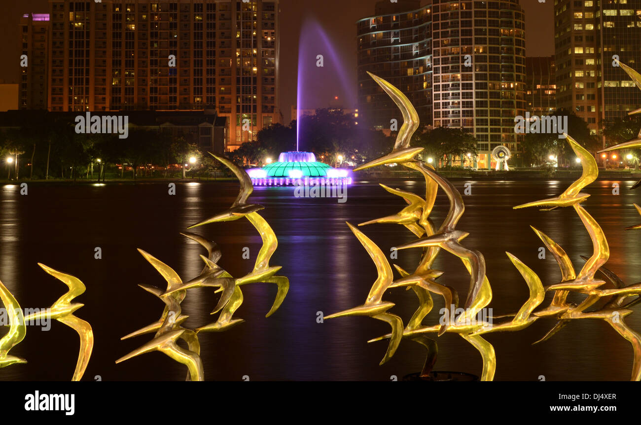 Vedere Arte Scultura Orlando " prendere il volo' dall'artista Douwe Blumberg sul Lake Eola con il centro cittadino di Orlando, Florida e fontana. Foto Stock