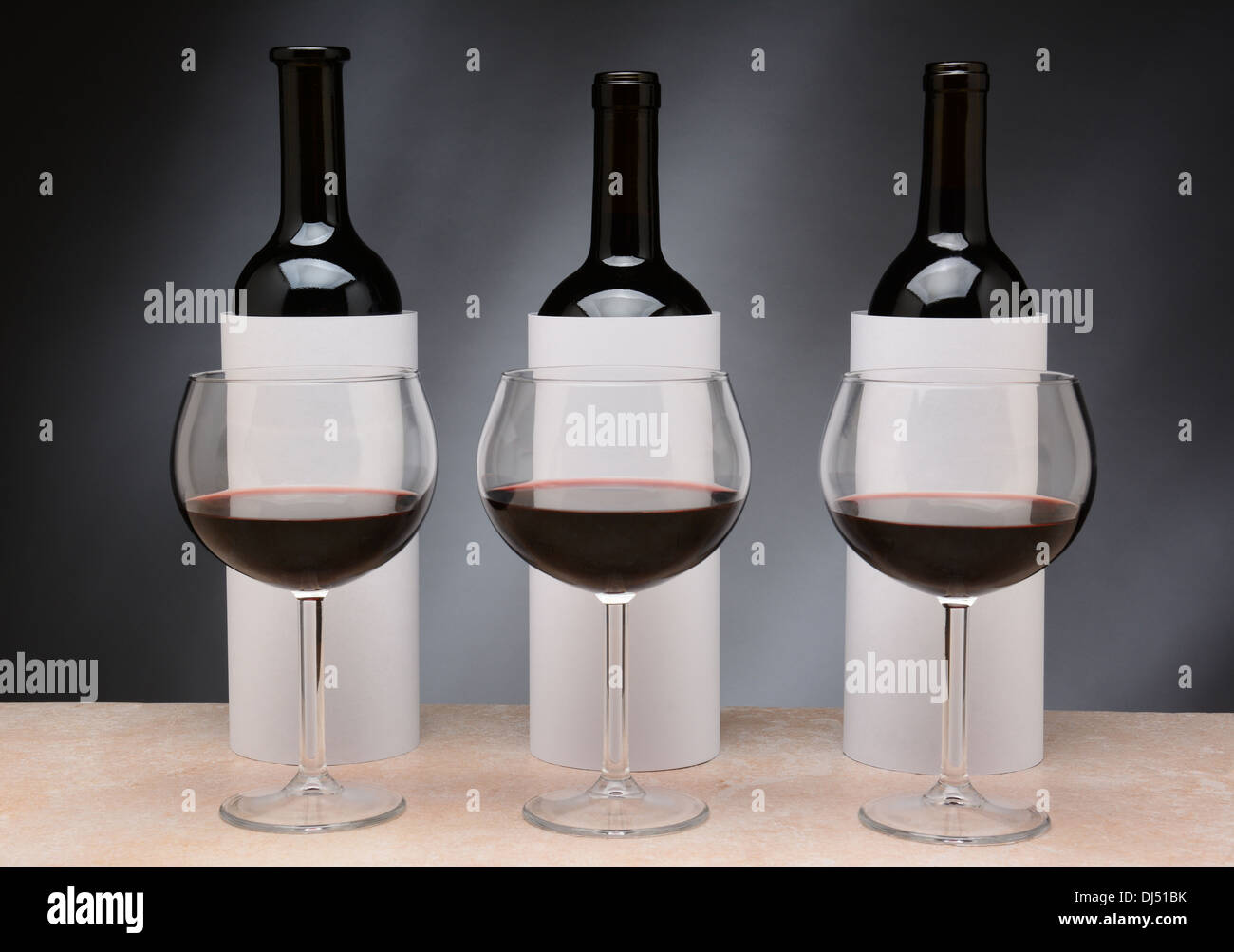 Tre diverse bottiglie di vino impostato per ciechi una degustazione di vino. Le bottiglie sono coperti da cilindri di vuoto Foto Stock