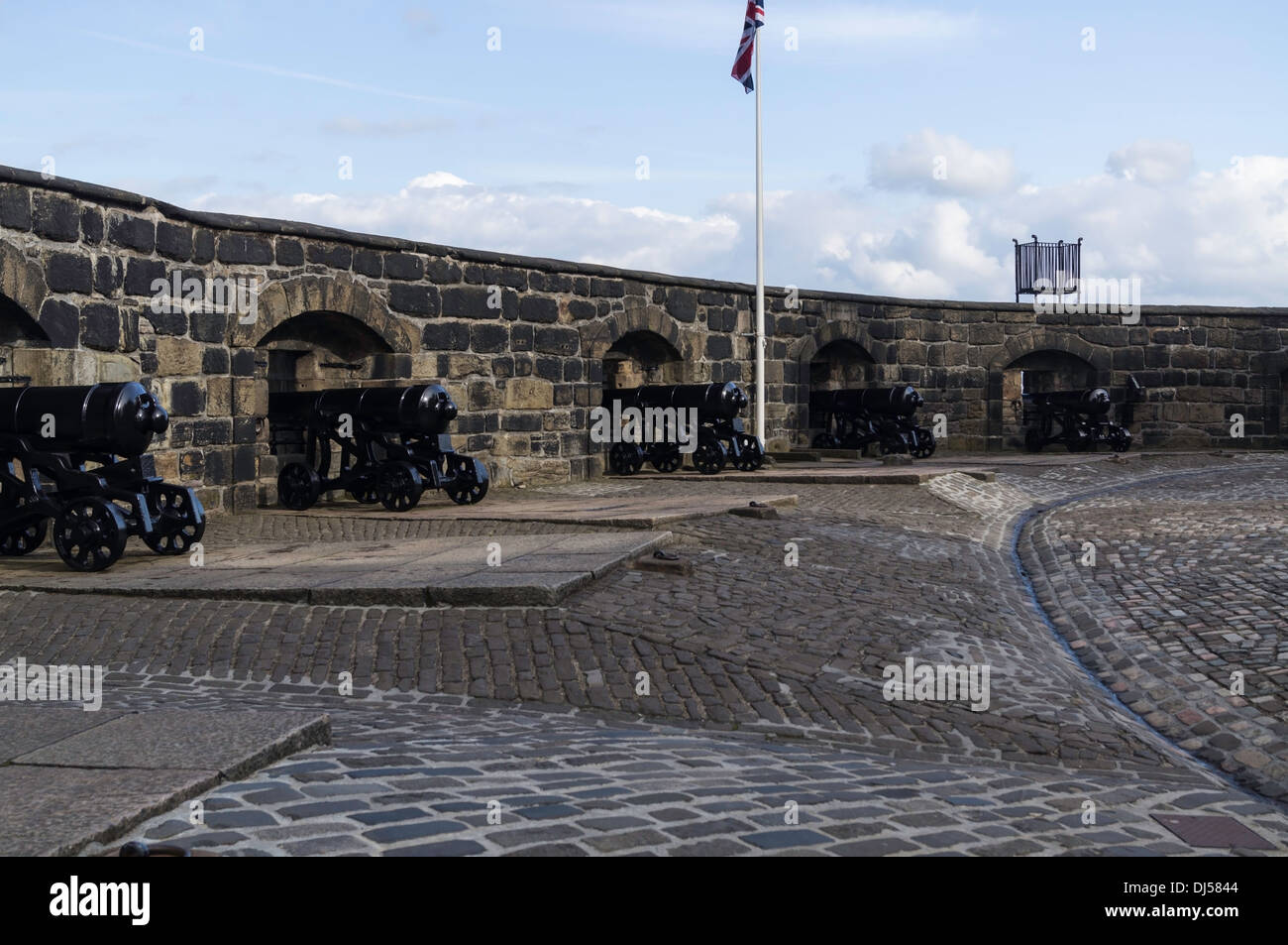 Fila di cannoni nella sezione superiore del Castello di Edimburgo in Scozia, insieme con l'Unione Jack Foto Stock