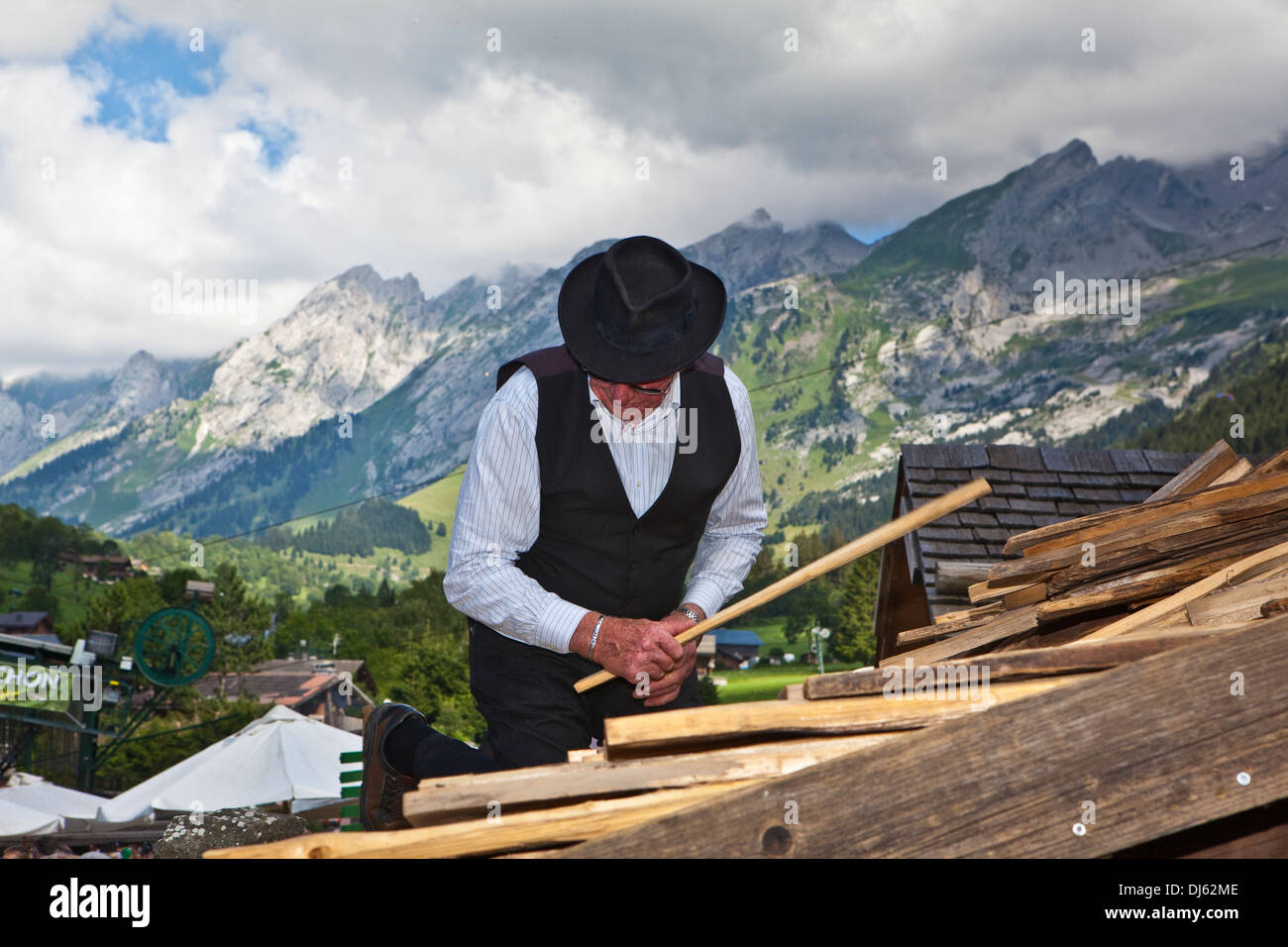 Uomo che ricopre il tetto di uno chalet con scuote (herpes zoster) Foto Stock