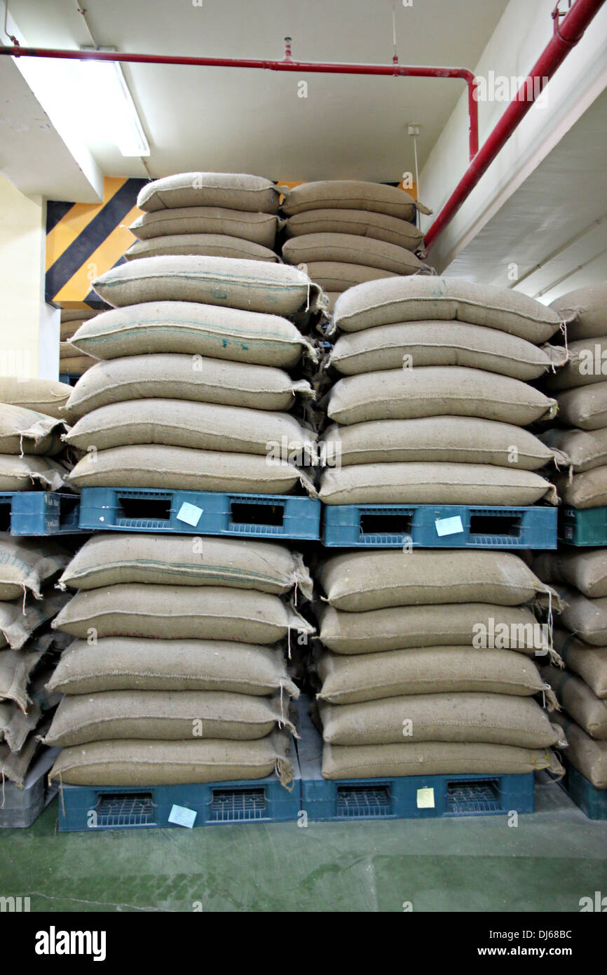Impilati di riso sacchi su pallet in plastica in magazzino. Foto Stock