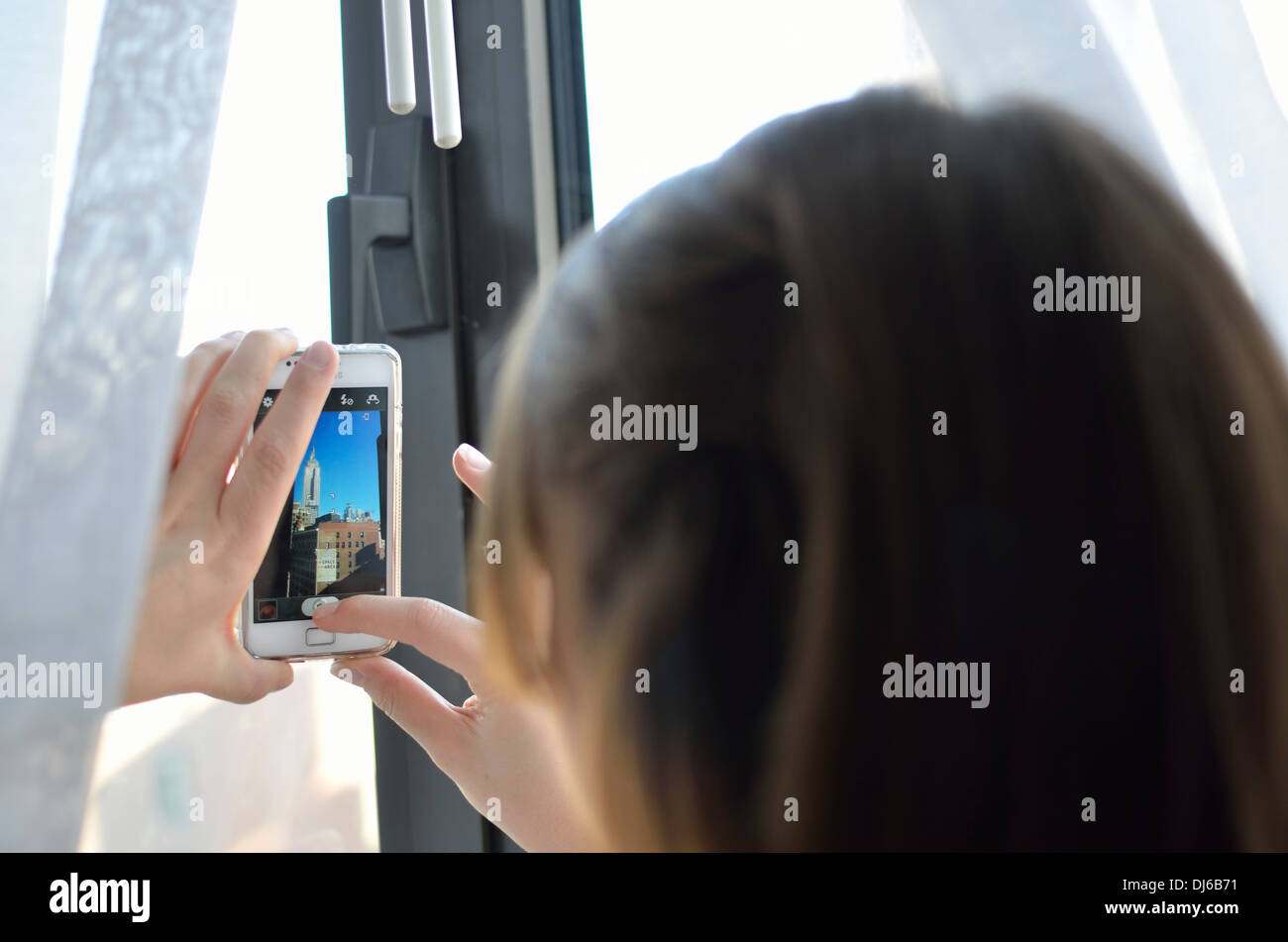 Donna di scattare una foto dell'Empire State building su un bianco Samsung fotocamera del telefono Foto Stock