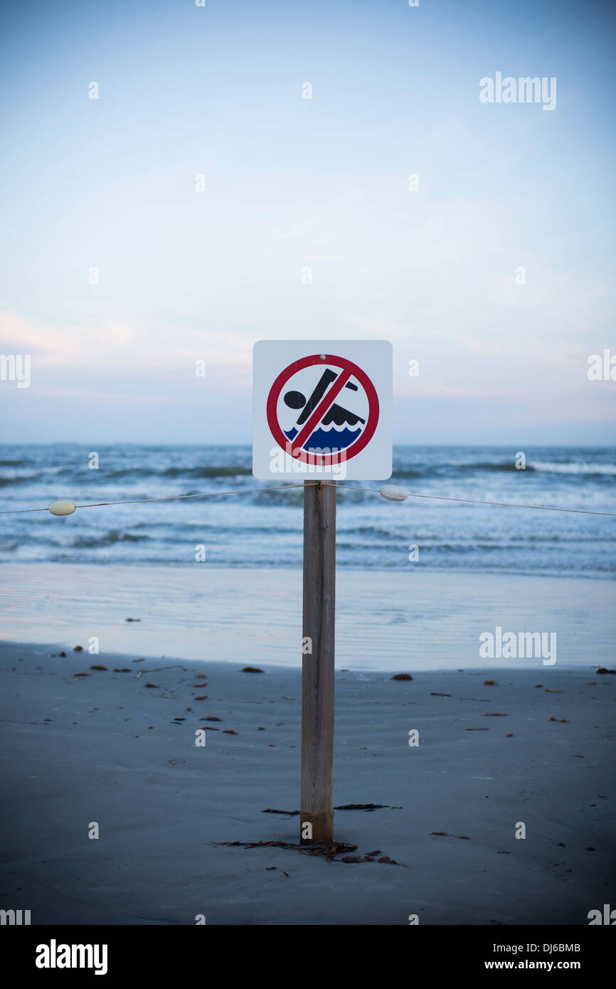 Un nessun segno di nuoto su una spiaggia al tramonto in Galveston, Texas, Stati Uniti d'America. Foto Stock
