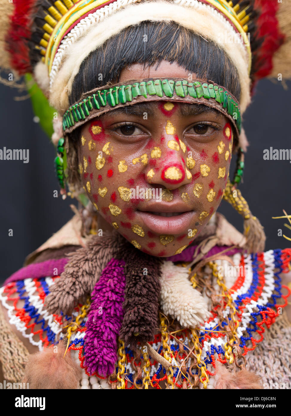 Tribal ragazza con il giallo e il rosso puntino di vernice sulla faccia, Goroka Show, Papua Nuova Guinea. Foto Stock