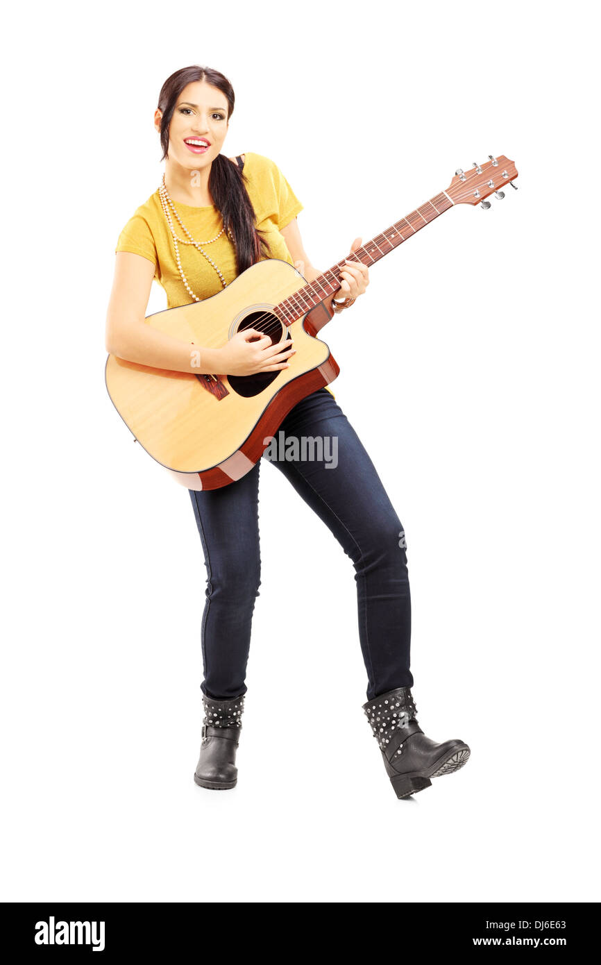 A piena lunghezza Ritratto di una giovane donna musicista suonando una chitarra acustica Foto Stock