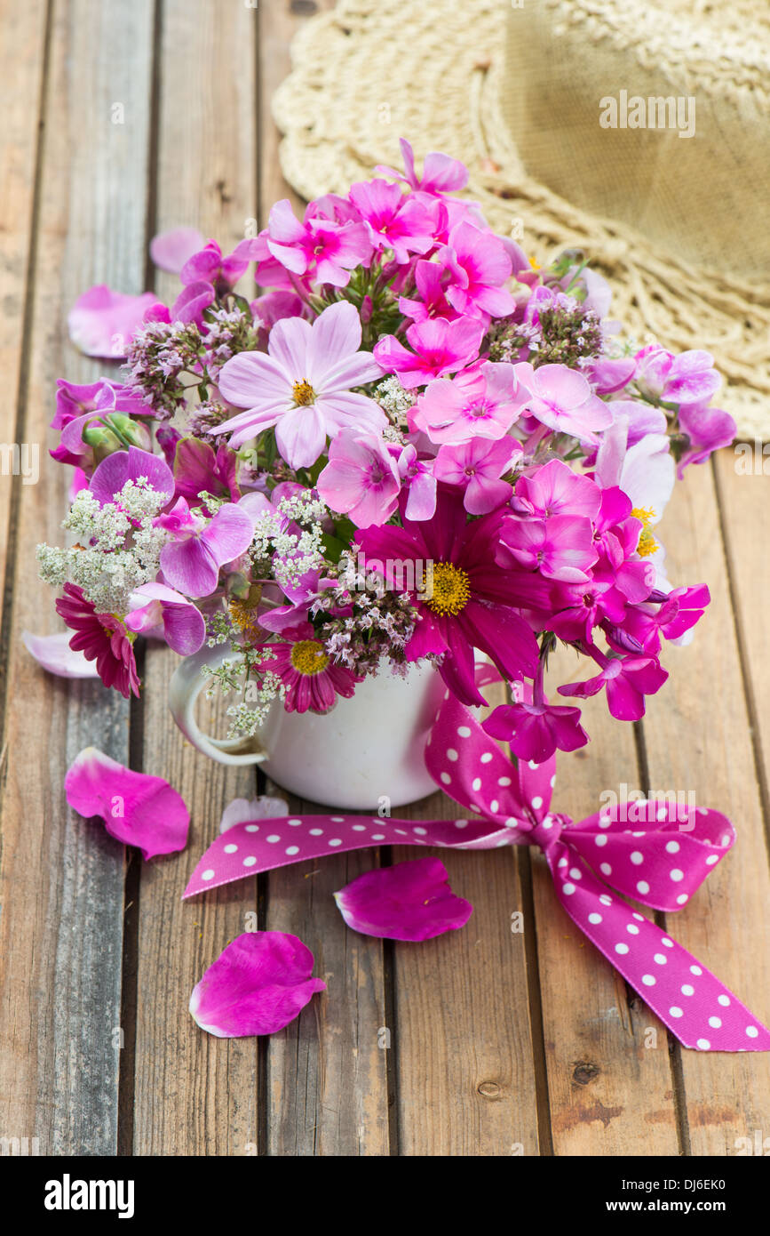 Rosa fiori da giardino in un vecchio cup Foto Stock