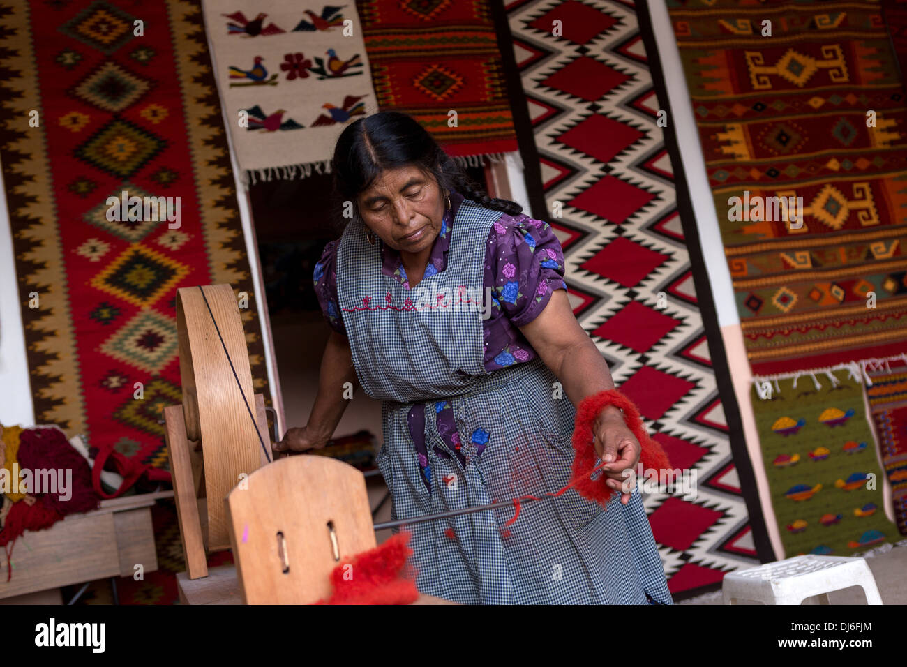 Un zapoteco donna indigena spin mano lana tinti in filo per essere utilizzati nella tessitura dei tappeti tradizionali in Teotitlan, Messico. Foto Stock