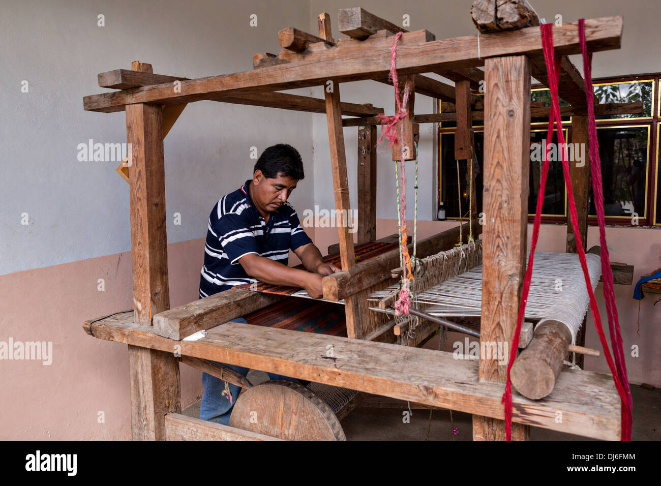 Un indigeno zapoteco uomo utilizza un lato telaio per la tessitura dei tappeti tradizionali Ottobre 30, 2013 in Teotitlan de Valle, Messico. Foto Stock