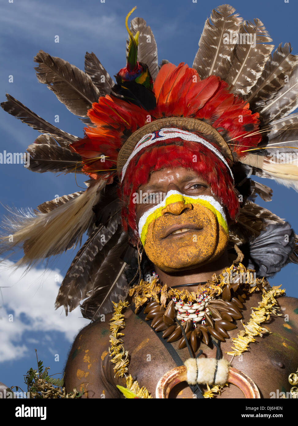 Uomo tribale con la faccia di vernice e di selvaggina di penna copricapo a Goroka Show singsing festival, Goroka, Papua Nuova Guinea Foto Stock