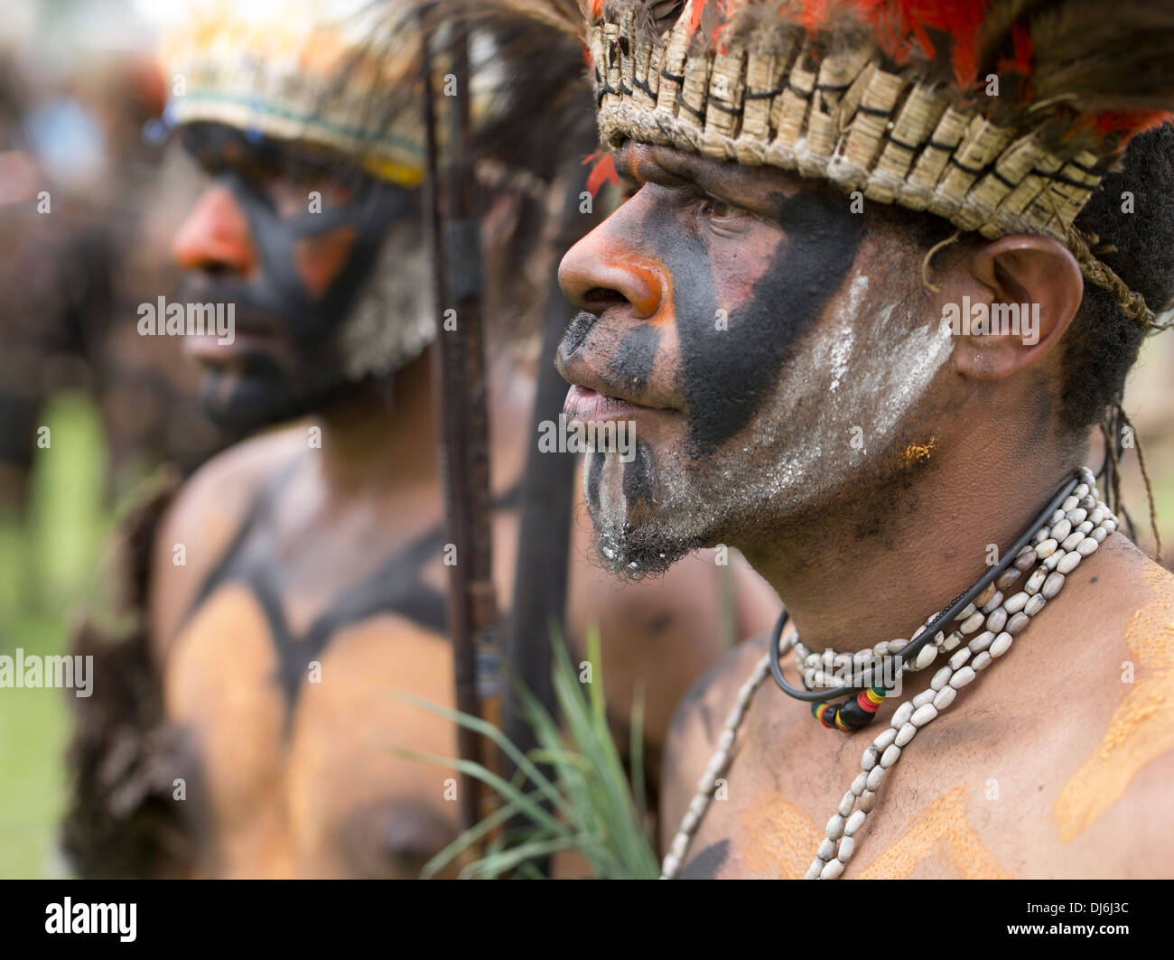 Tribal gli uomini con la faccia di vernice e lance a Goroka Show festival singsing Papua Nuova Guinea Foto Stock