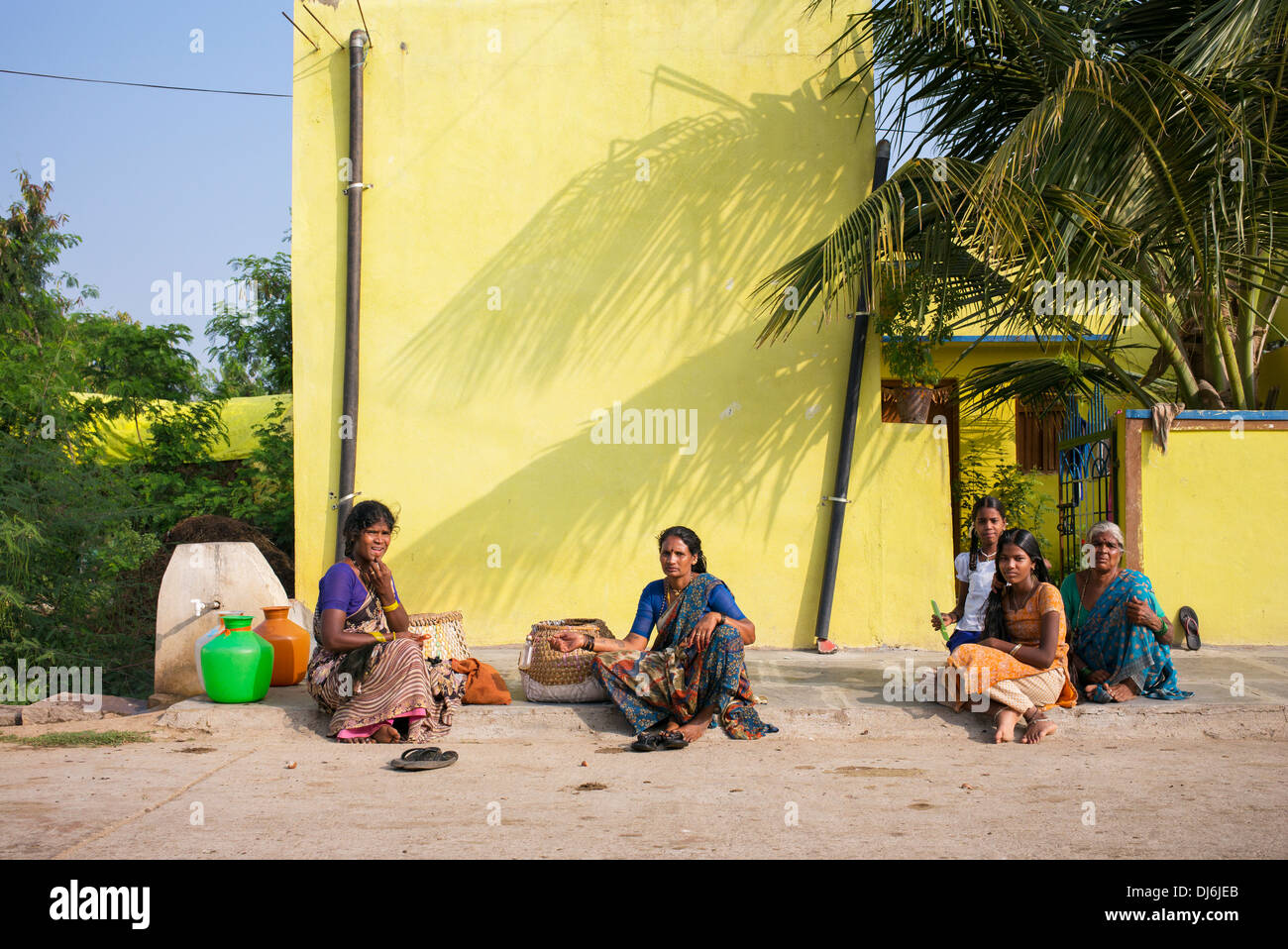 Rurale villaggio indiano di donne e ragazze sat in strada in una zona rurale villaggio indiano. Andhra Pradesh, India Foto Stock