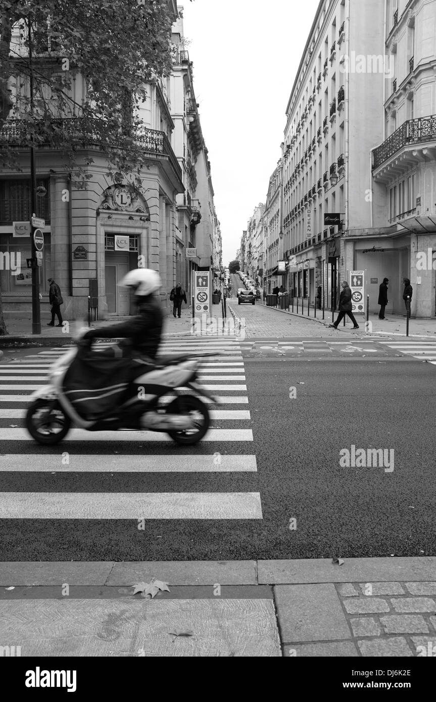 Ciclomotore passando sopra le strisce pedonali a Parigi, Francia Foto Stock