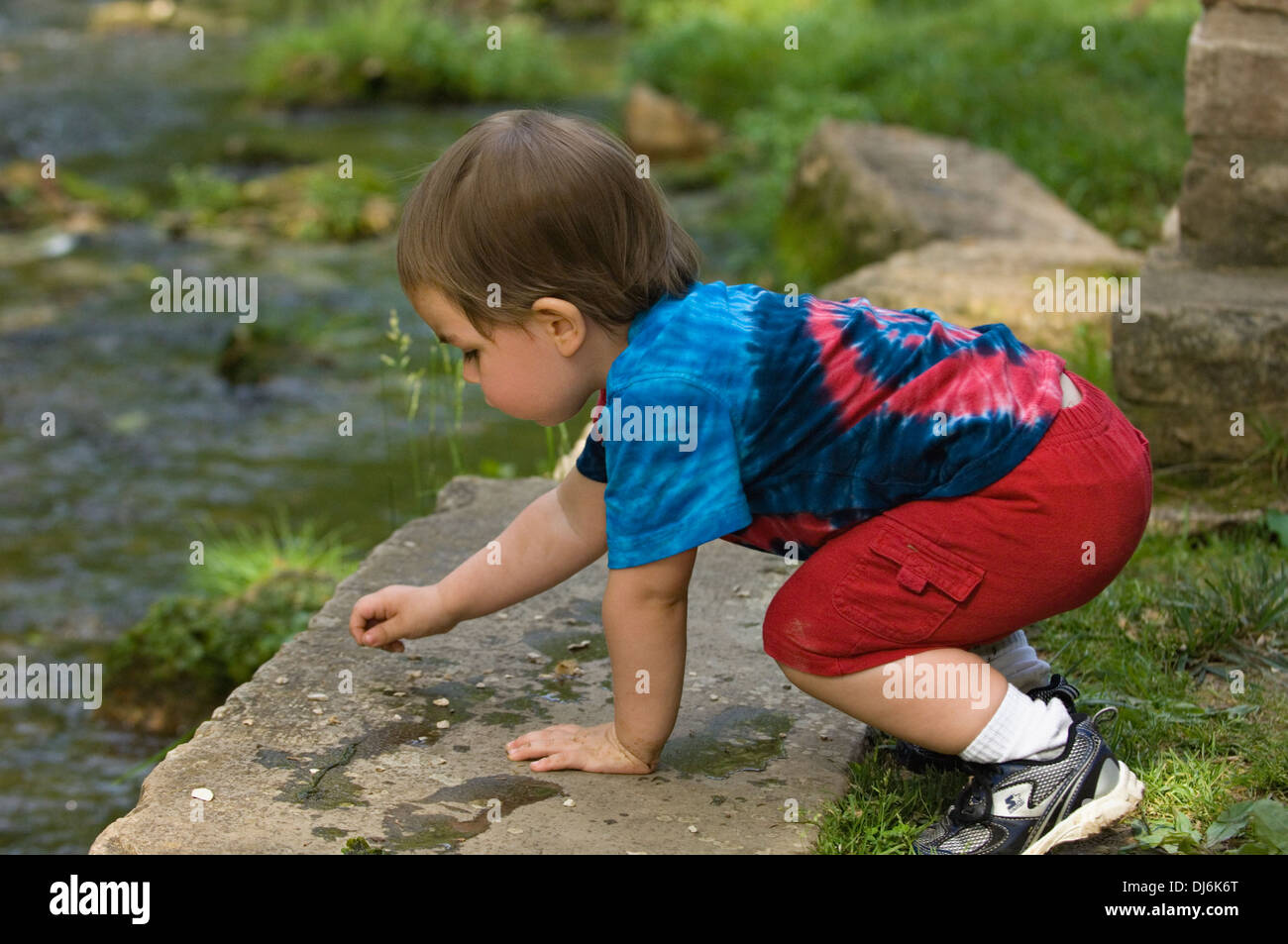 Il Toddler giocando vicino Creek a molla stato Mill Park in Indiana Foto Stock