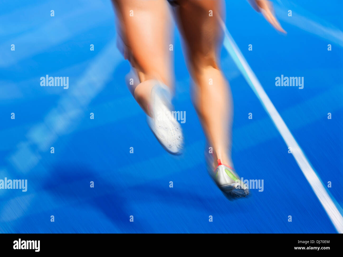 Gambe del femminile sfocato sulla pista azzurra Foto Stock