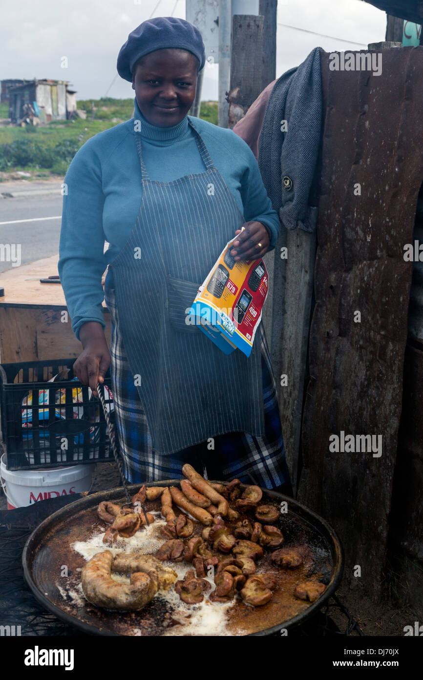 Sud Africa, Cape Town, Guguletu Township. Street Food Vendor salsicce di cottura. Foto Stock